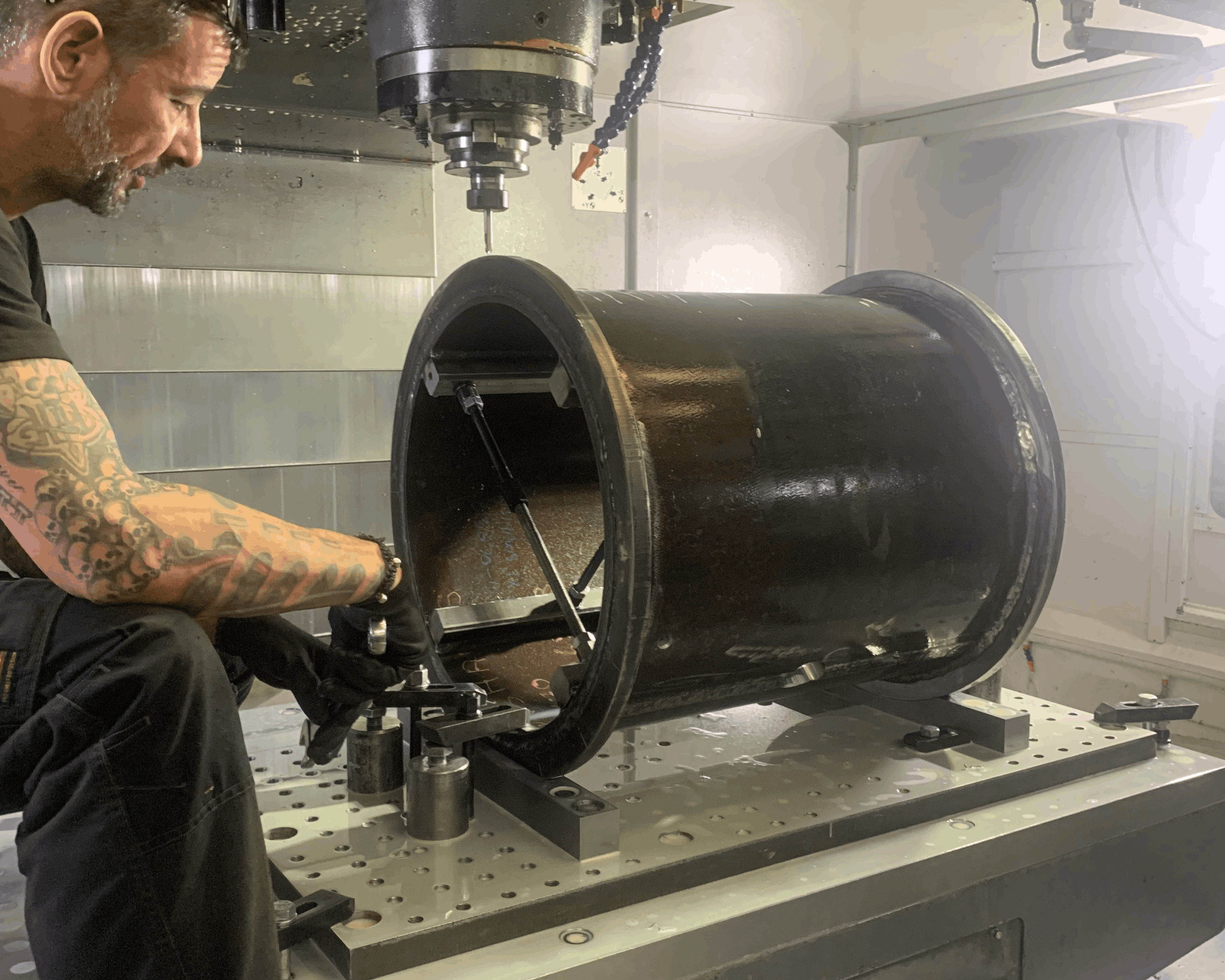 A man using a CNC machine milling to manufacture bespoke parts. 