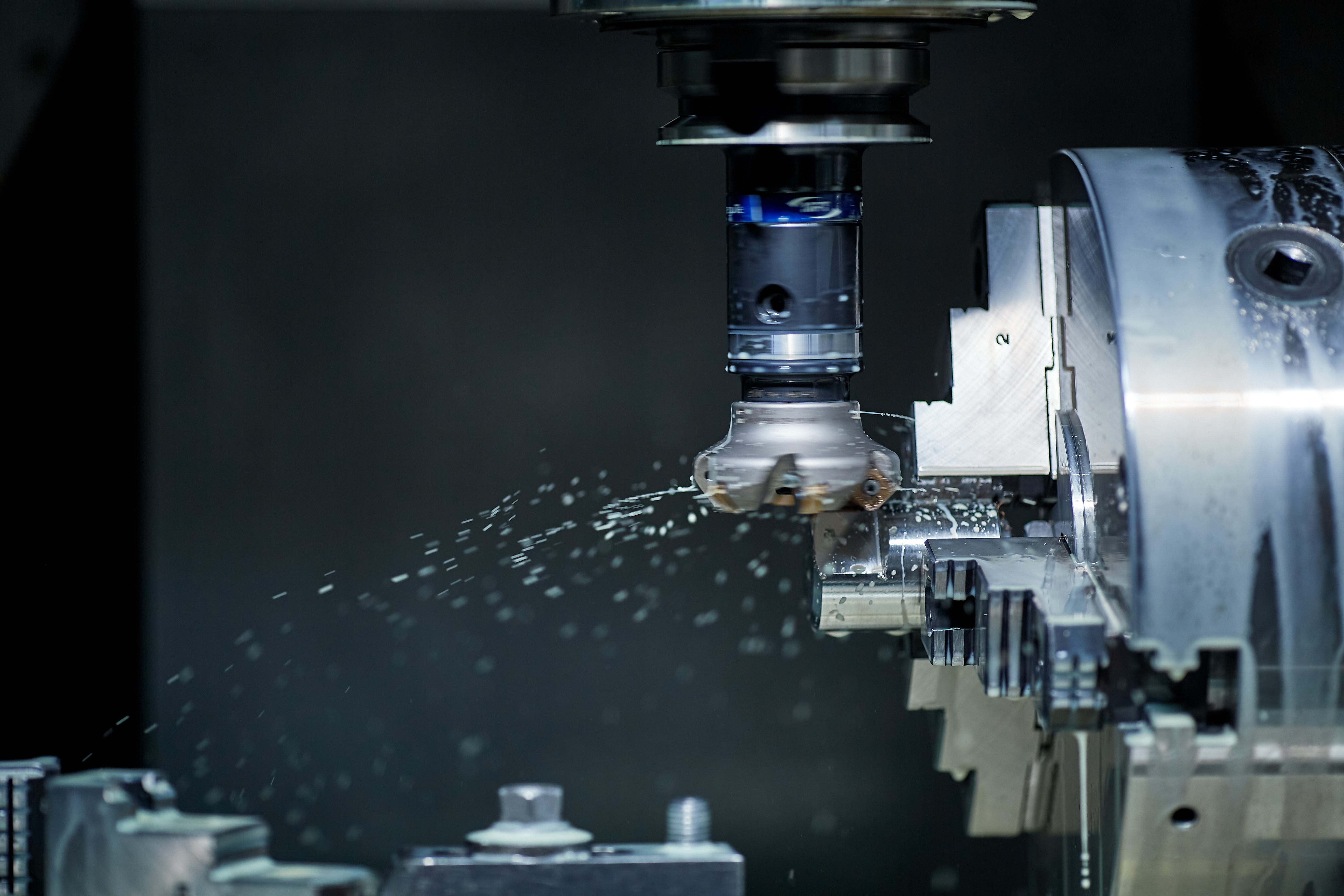 CNC machine cutting a metal component during a precision machining process in an engineering workshop.